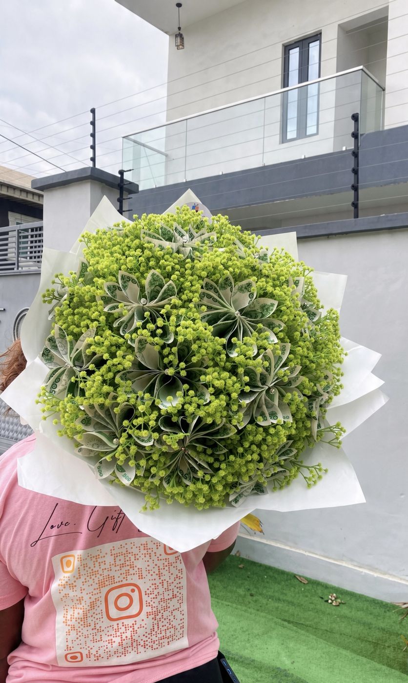 Bouquet styled from folded naira notes, held up outdoors